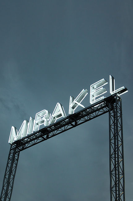 Mirakel Logo auf einem Dach bei Nacht aus Neonlicht