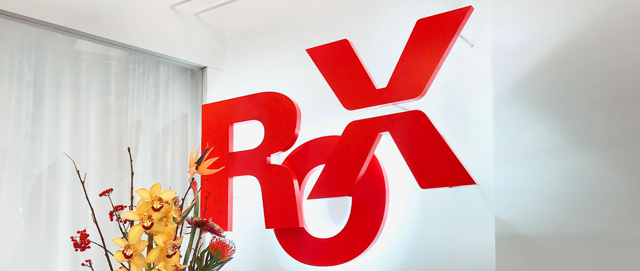 Der Schriftzug Rox in roten 2D Buchstaben mit weißem Hintergrundlicht an einer Wand montiert